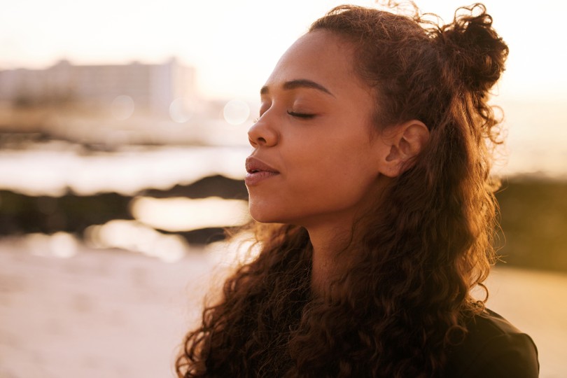 Person practising calming breathing near water